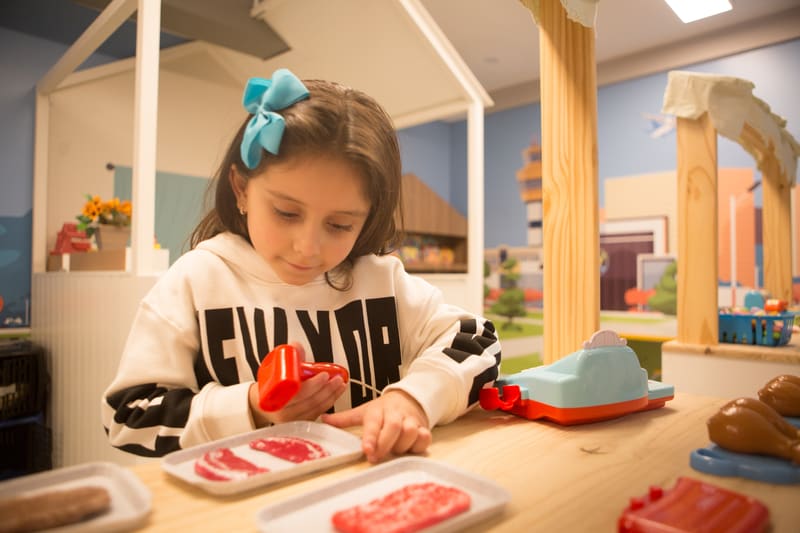 Criança em idade escolar durante sessão de terapia com material da Clínica Formare